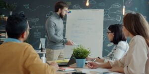 Réunion d'équipe autour d'un paperboard de stratégie commerciale dans un bureau moderne