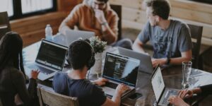 Petite équipe travaillant sur des ordinateurs portables autour d'une table dans un espace de coworking